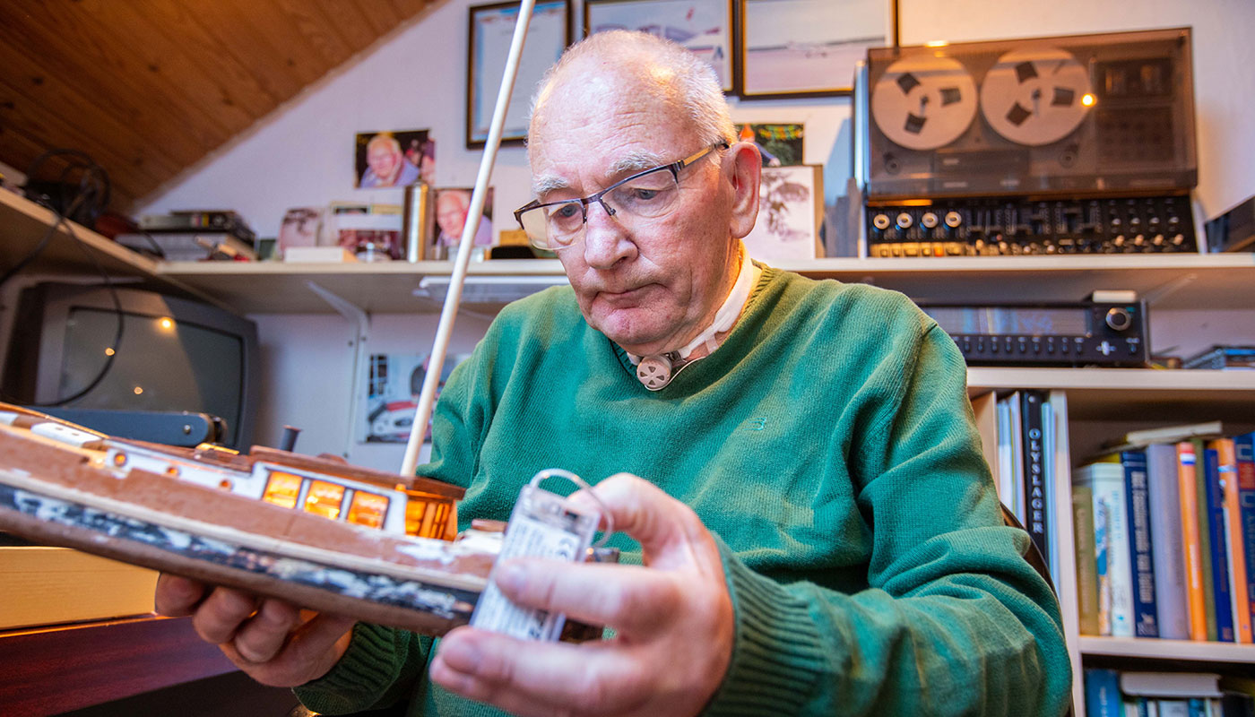 Man in his study using Freevent DualCare while assembling a model ship.